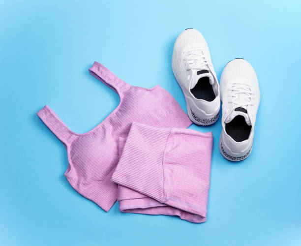 Lilac sports leggings and bras, white sneakers on a blue background.