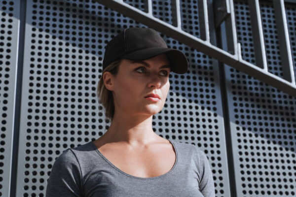 Portrait of confident woman athlete black baseball cap outdoor.