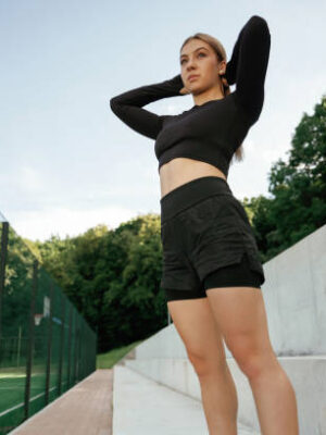 Beautiful fitness woman in sport clothes is outdoors.