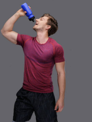 A man in a red t shirt holds bottle of water.
